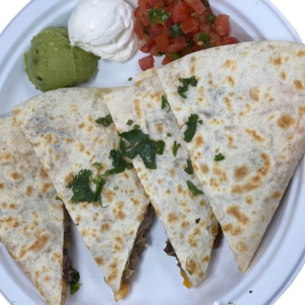 Four quesadilla slices with cilantro, served with guacamole, sour cream, and pico de gallo.